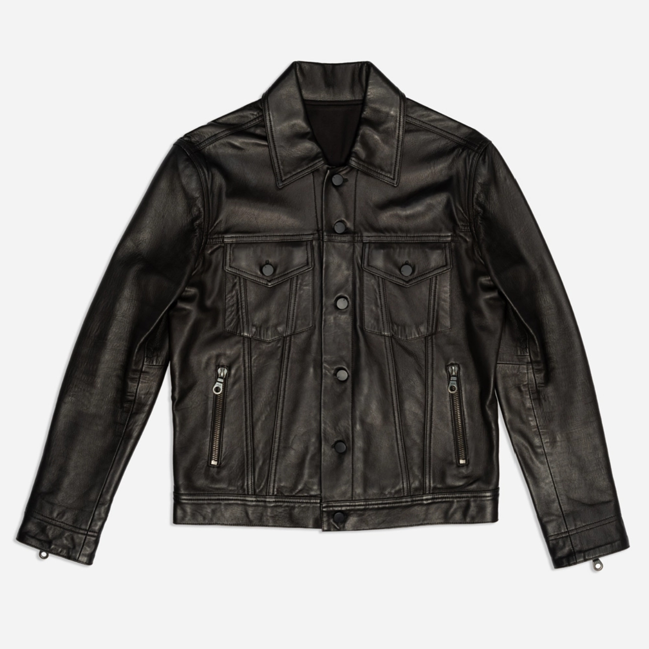 Black leather jacket with a classic design, featuring a collar, two chest pockets, and zipper details, laid flat on a white background — A Los Angeles photography studio portfolio